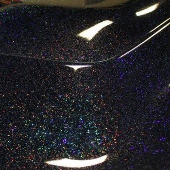 Black holographic flake on a car hood.