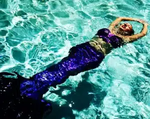 Mermaid with a red-blue-purple silicone tail for swimming.
